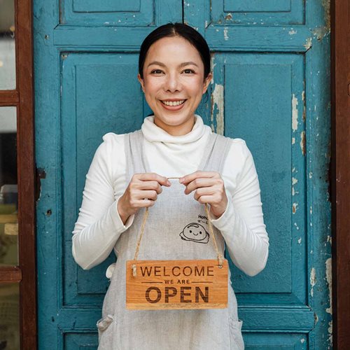 Woman holding open sign